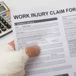Injured hand holding Work Injury Claim Form